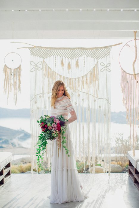 macrame backdrop and bride with bouquet