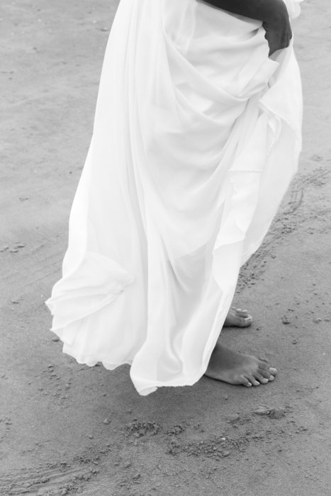 black and white moody image of brides feet on the beach destination wedding