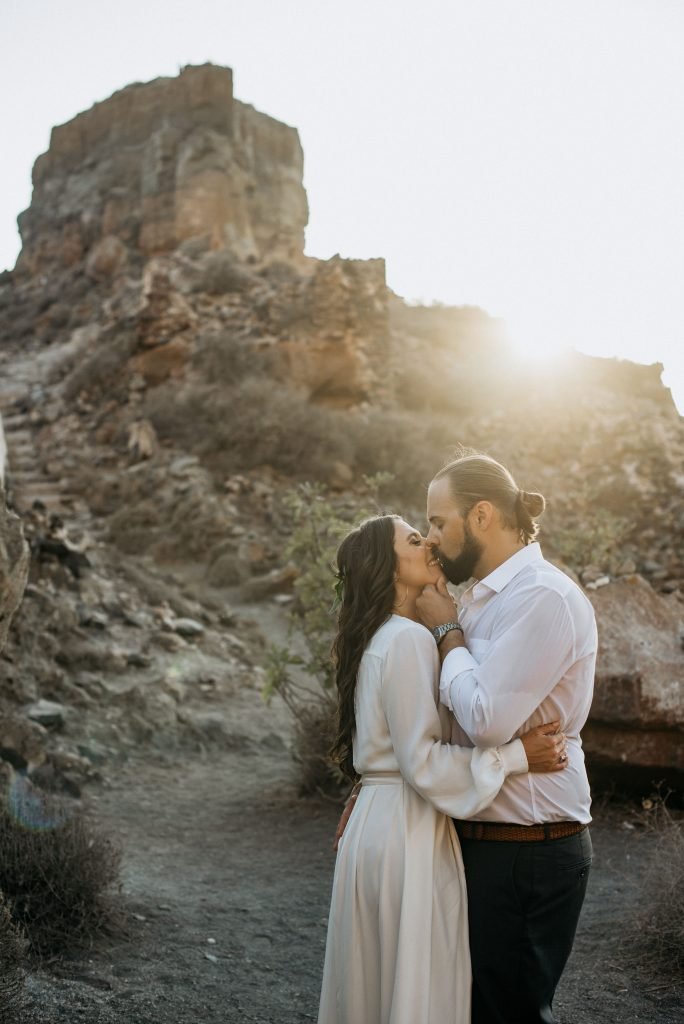 Couple kissing on the rocks in Santorini