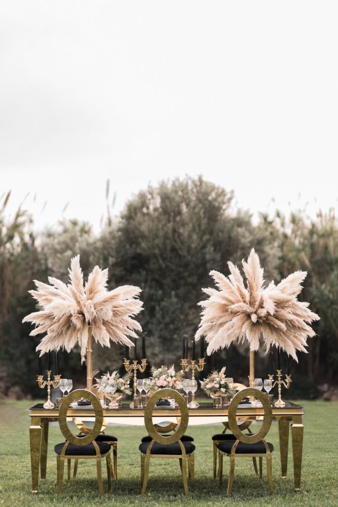 Wedding in gold table with pampas grass and golden chairs 