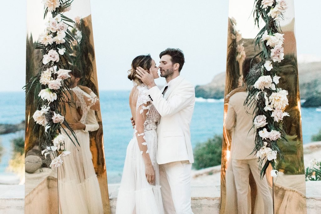 Bride and Groom Kissing in front of the Mirror Columns backdrop in Mykonos