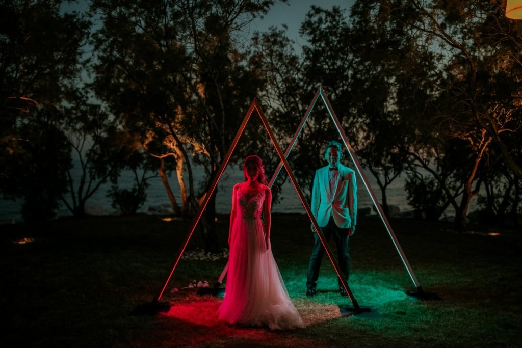 Wedchella wedding bride and groom standing under neon arches