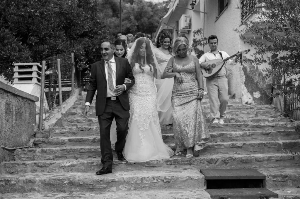 Bride walking to the church with her father and family 