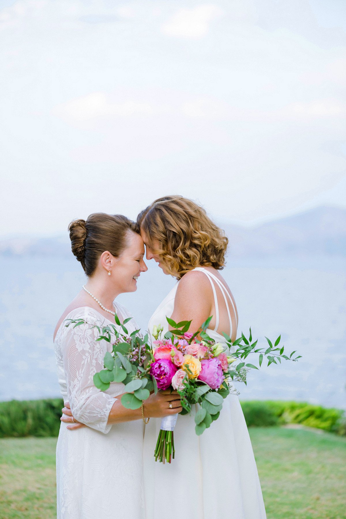Two brides hugging in joy after their wedding ceremony