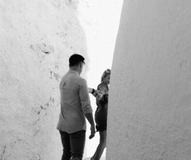 Secret Proposal Tips: Couple hiding between white alleys at their engagement lovestory on the Greeks island of Ios