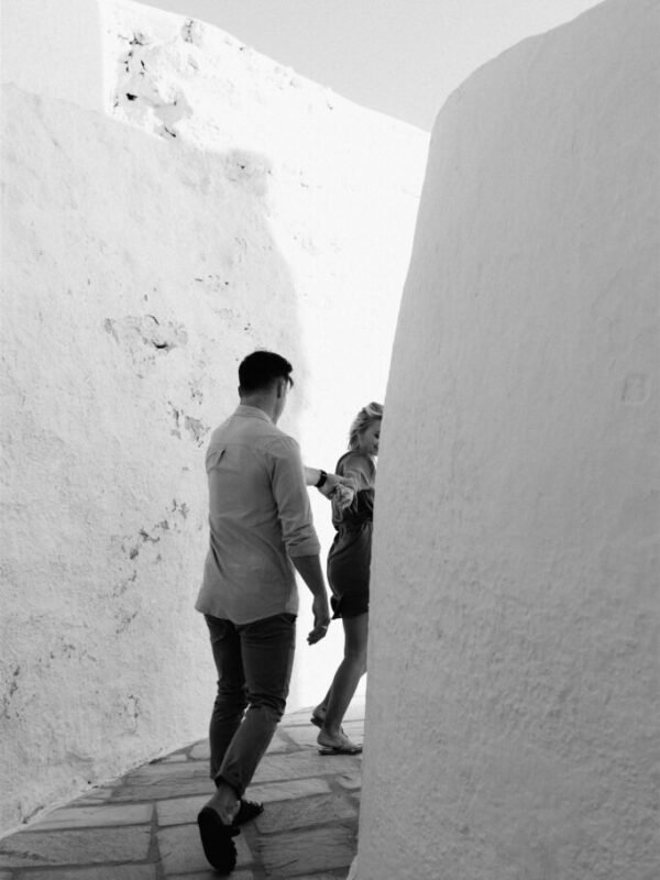 Secret Proposal Tips: Couple hiding between white alleys at their engagement lovestory on the Greeks island of Ios