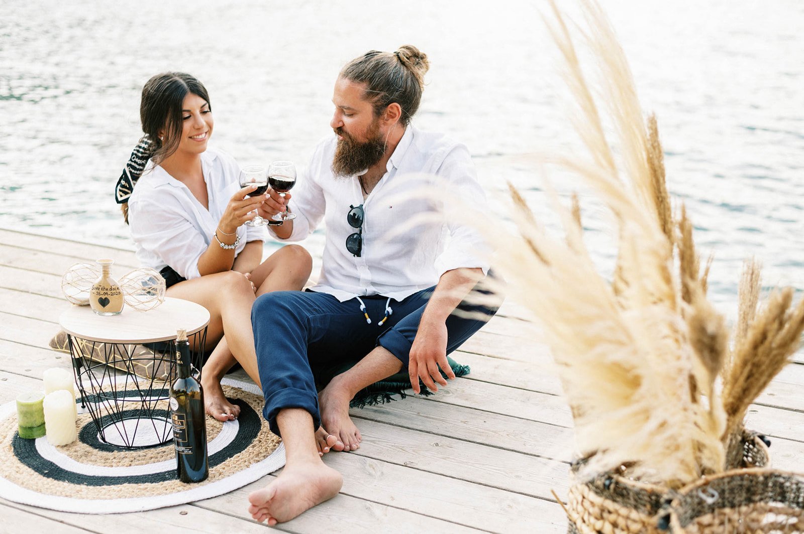 Couple sitting on the pier for t he most magical engagement shoot that ended with a sailing yacht ride