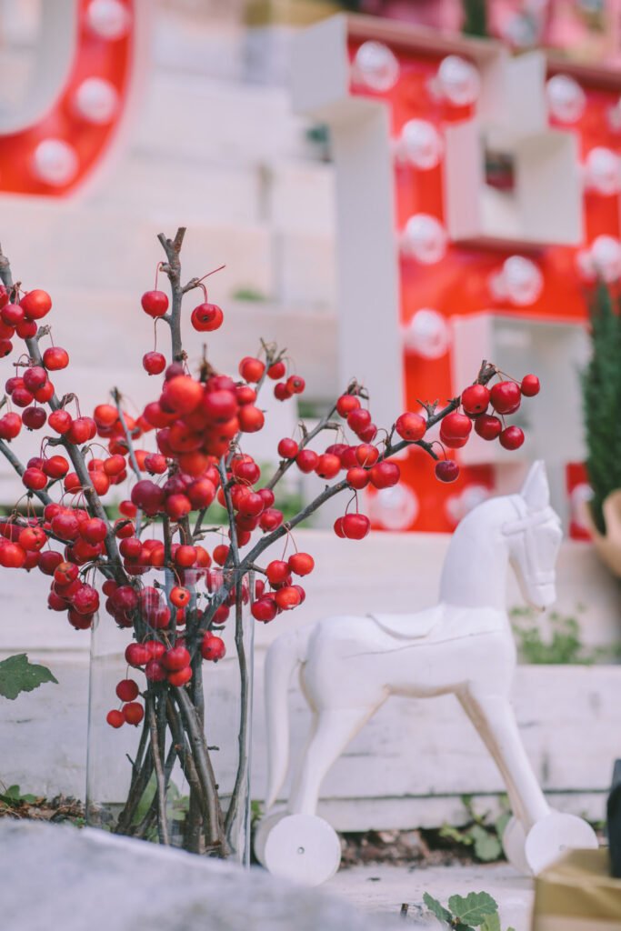 Christmas décor with red berries and white toy horse