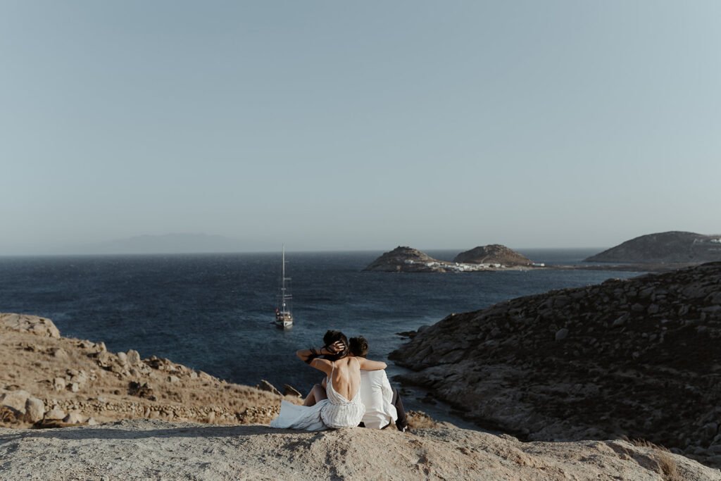 Bride and Groom Sitting on the cliff in Mykonos