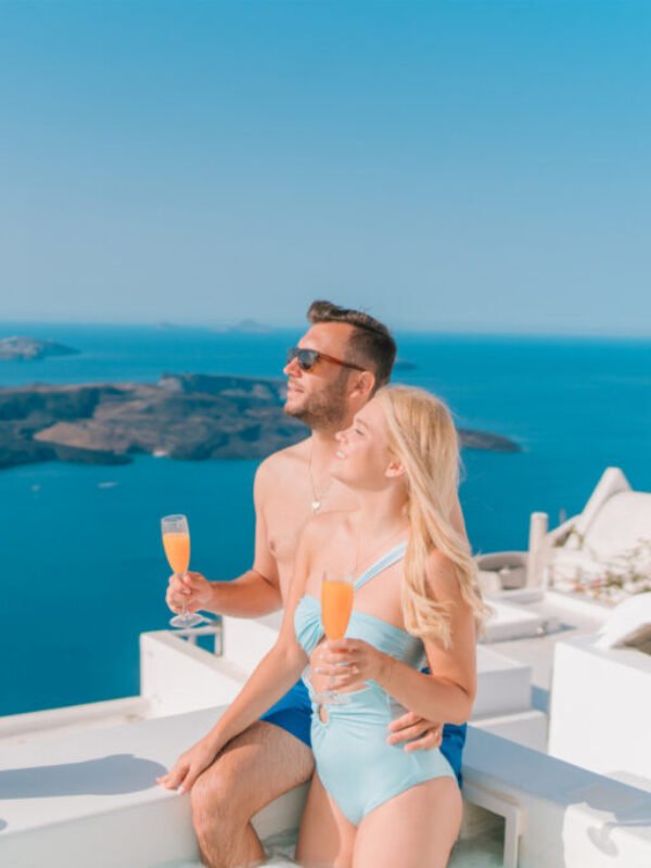 Instagram Influencer travel couple Gets Married in Greece drinking mimosas in Santorini