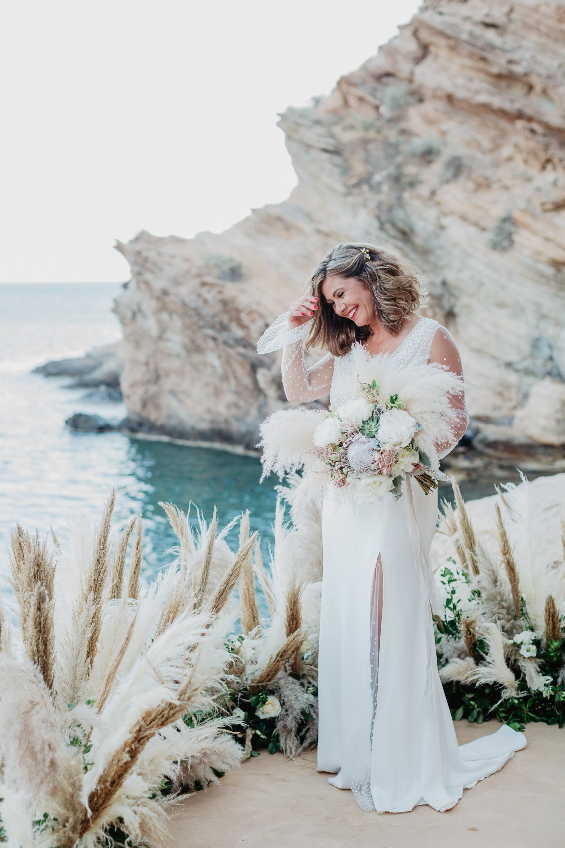 Happy bride on the rocks with boho decor