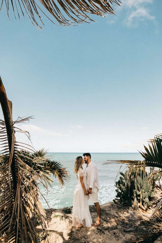 Couple standing between cactuses on the beach