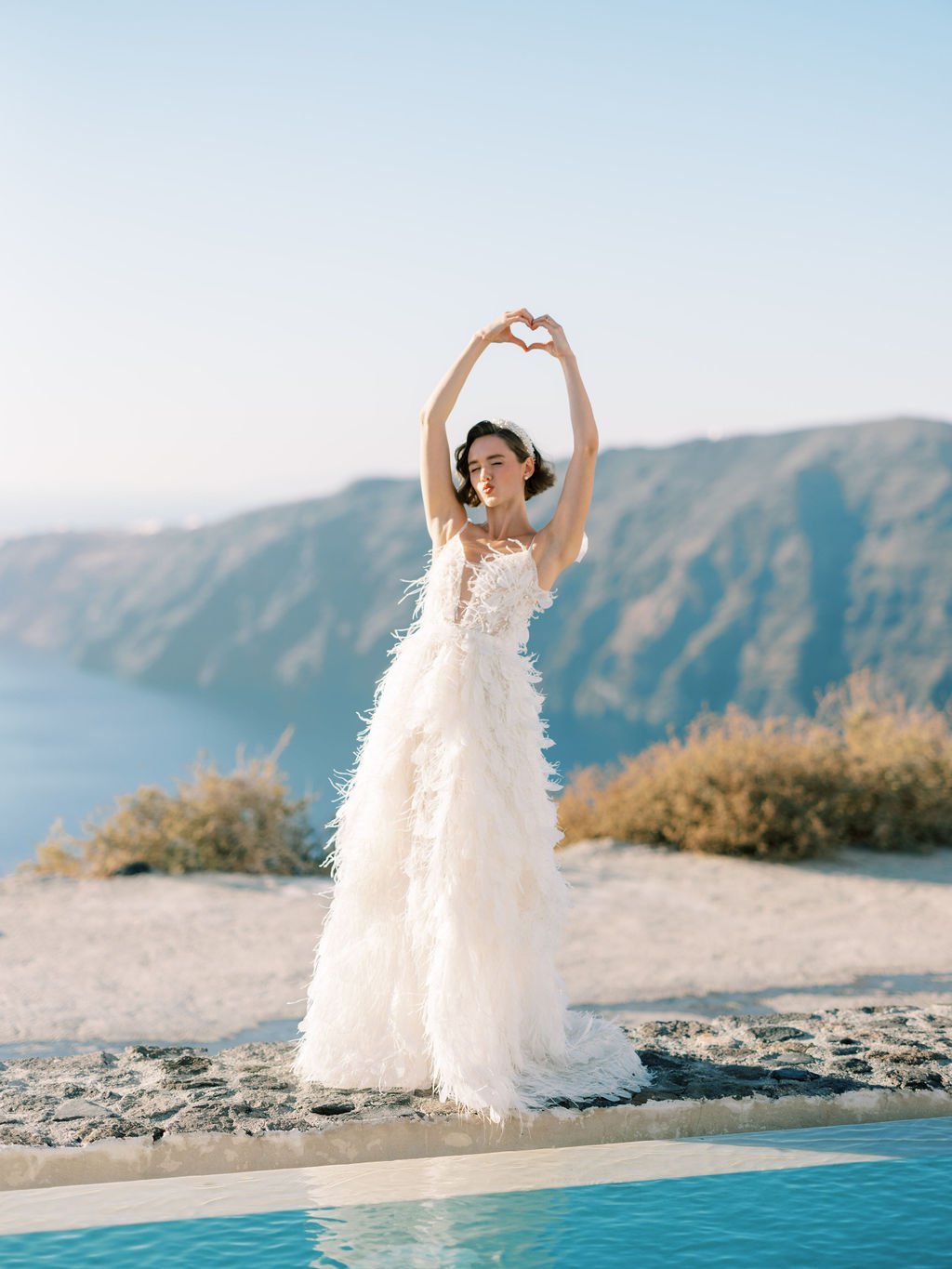 Bride sending hearts and kisses in Rocabella Santorini 