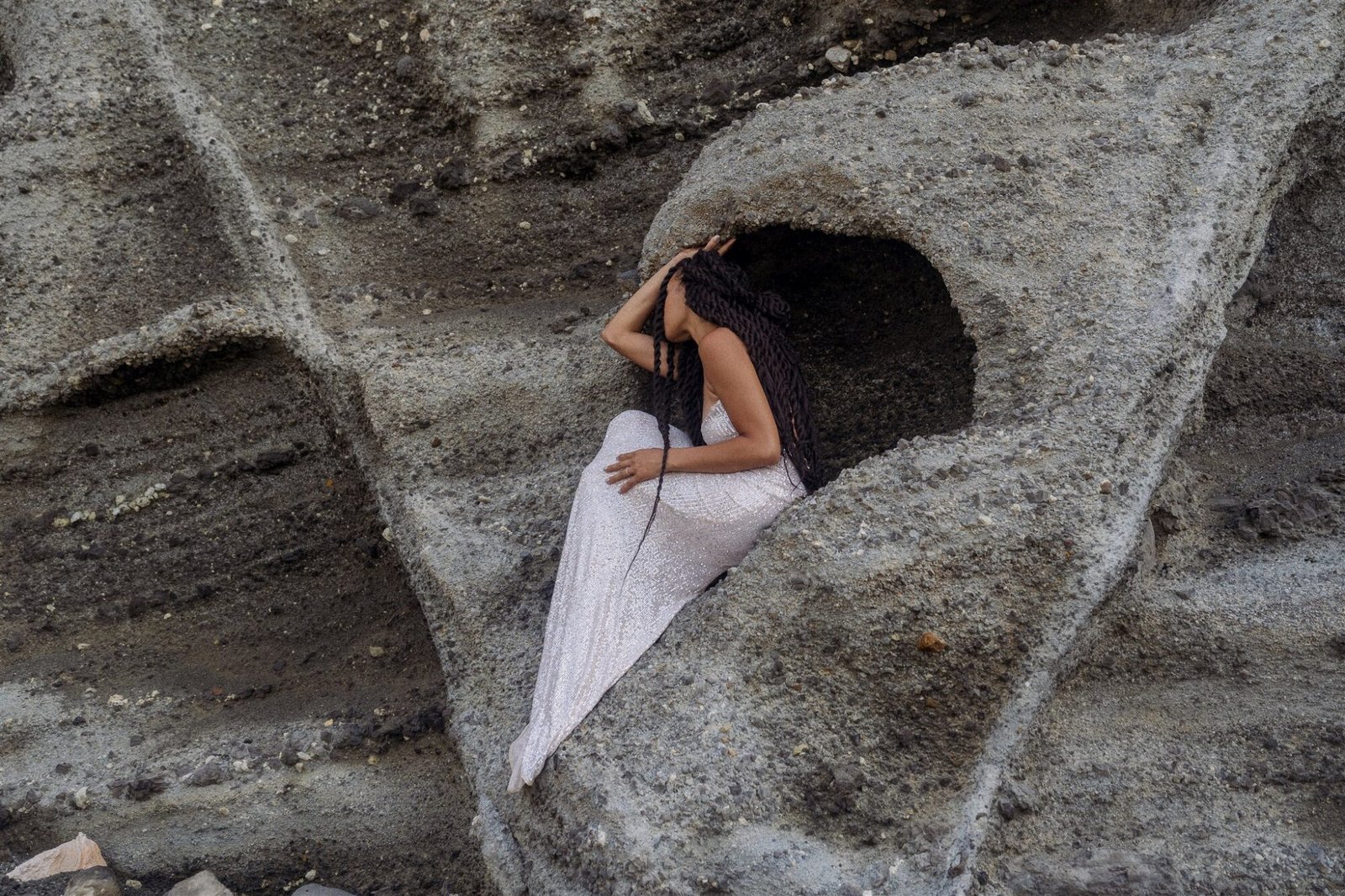 Celestial Elopement Inspiration Milos woman sitting as a mermaid in the cave of the rocks