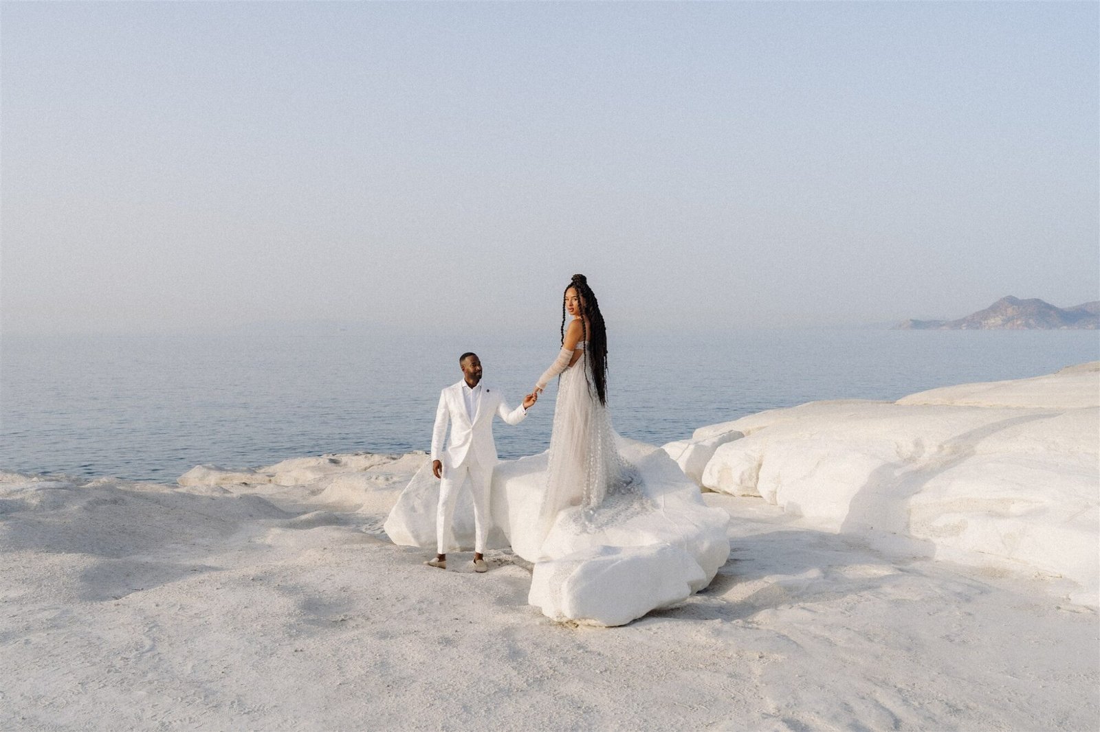 Couple standing in Milos on the white beach 