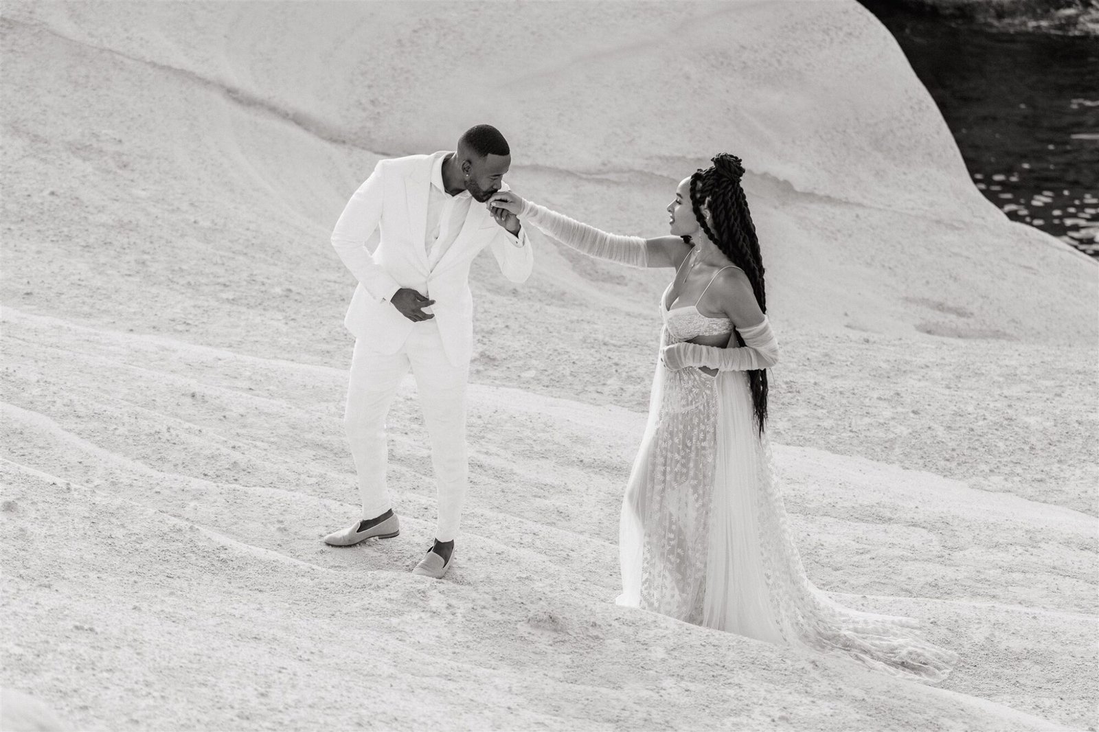 Celestial Elopement Inspiration Milos the groom kissing brides hand on sarakiniko beach