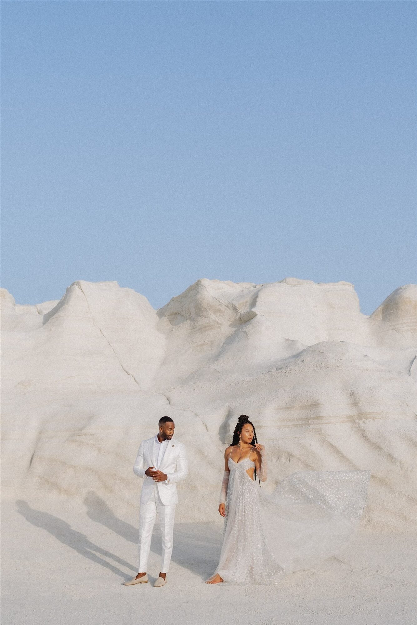 Couple standing on the white beach Celestial Elopement Inspiration Milos