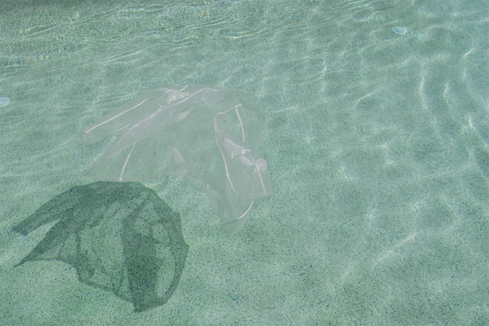 Celestial Elopement Inspiration Milos mans transparent white t-shirt floating in the pool 