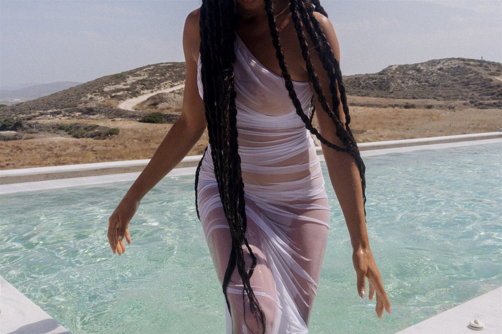 Celestial Elopement Inspiration Milos wet woman walking out of the pool with transparent white dress