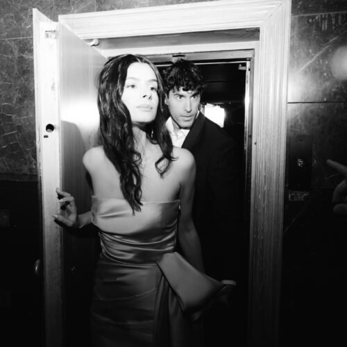 Black and white photo with flash of a couple in love exiting the elevator in their wedding resort hotel venue in Athens Greece