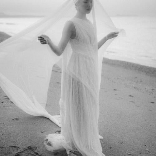 Destination Elopement in Rethymno, Crete, black and white image of a bride with veil on the beach