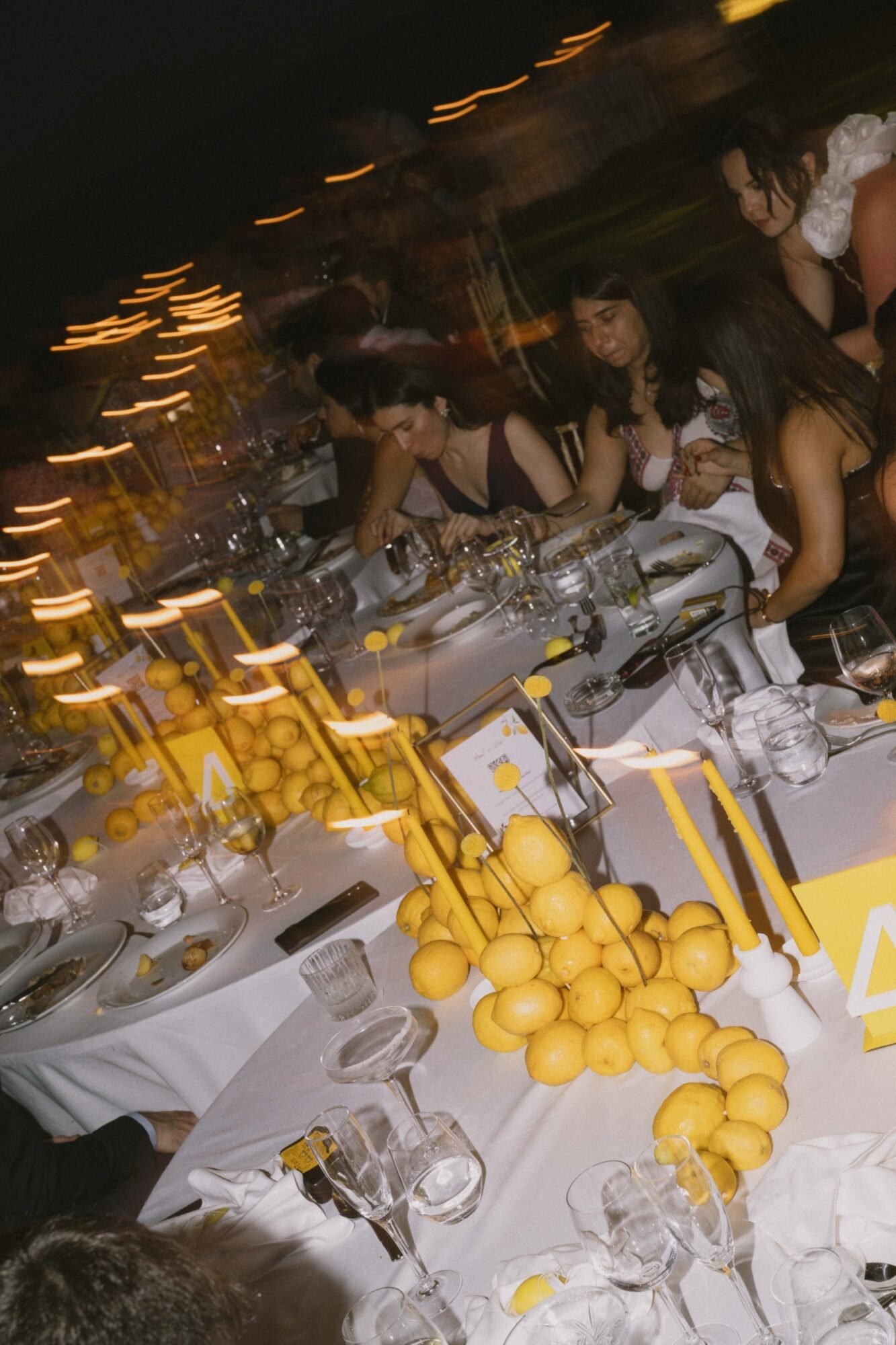 Lemon themed seaside wedding decor at The Island Riviera Athens with lemon tablescape and guests eating 