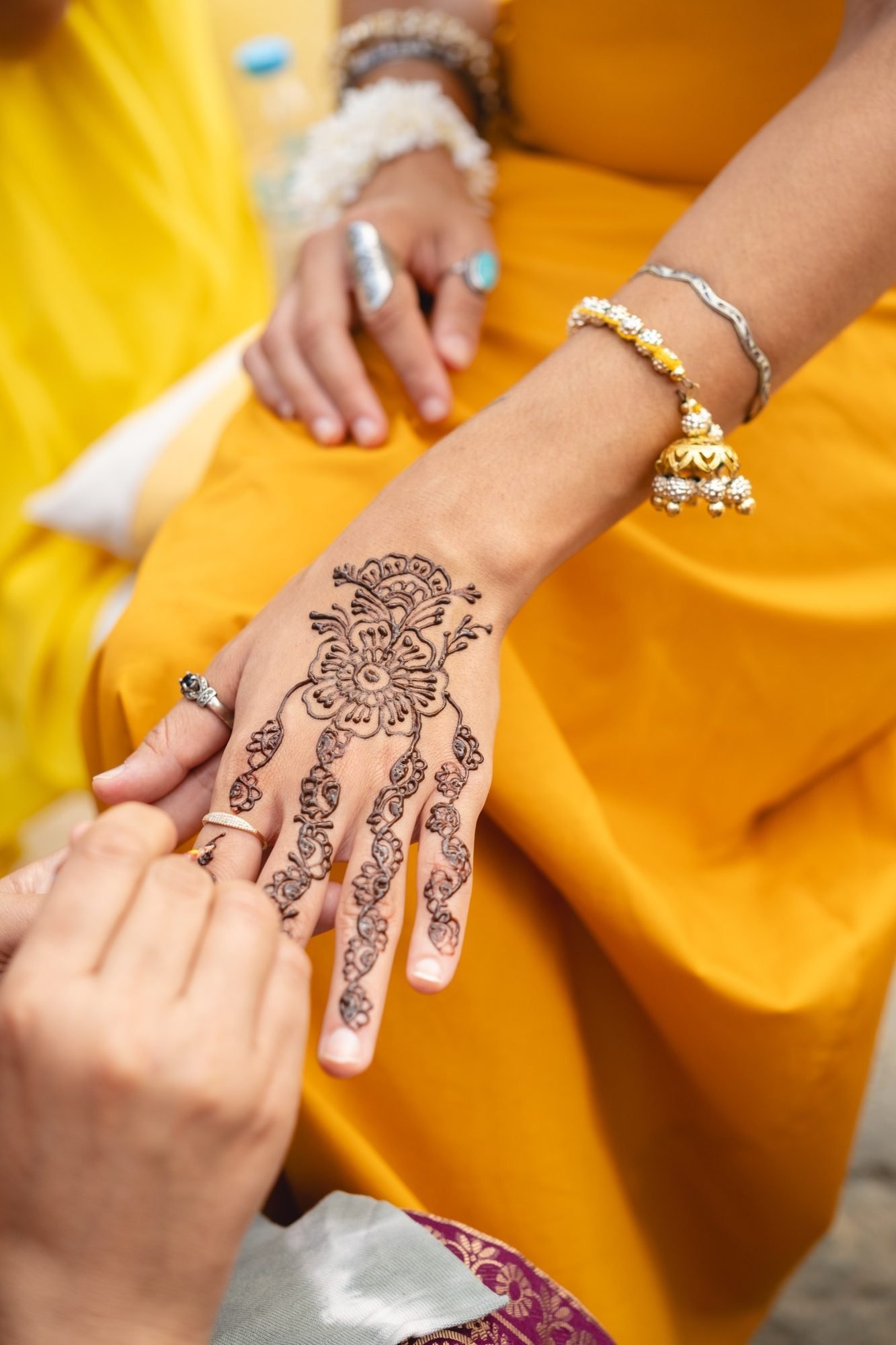 Henna Tattoo artist painting on hand and Haldi celebration in the Athenian Riviera