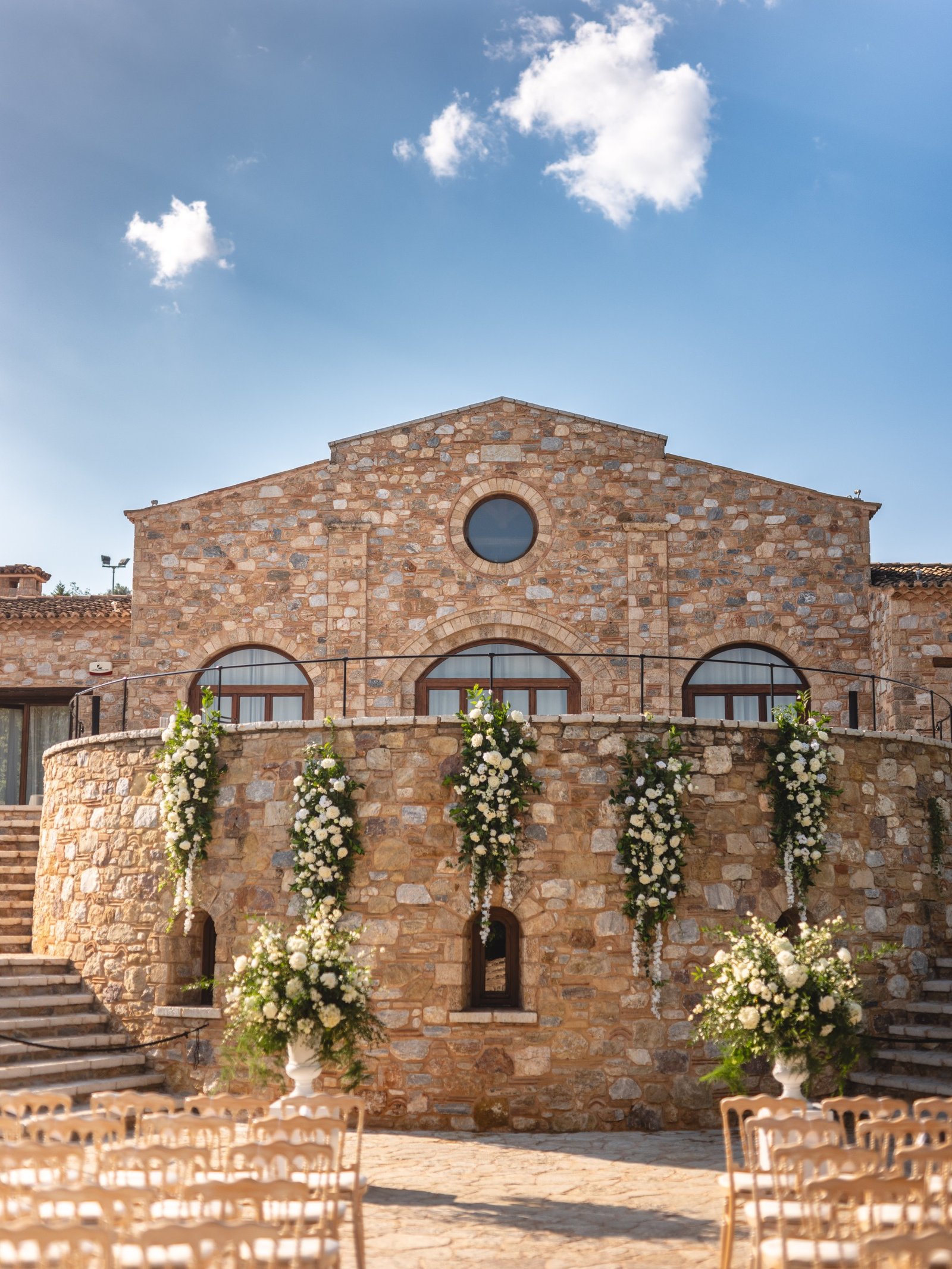 Wedding Decor with white flowers hanging from the balcony for a wedding ceremony at the Pyrgos Petreza vineyard venue in Greece