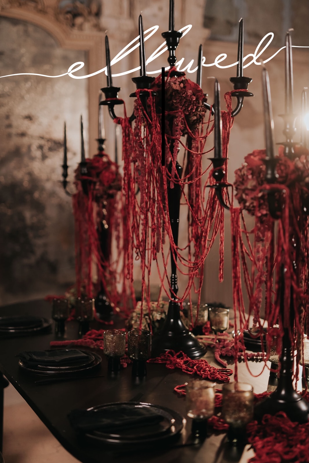 Dark romance wedding table in Greece with black candelabras, tapered black candles and deep red velvet strands draped across a black table