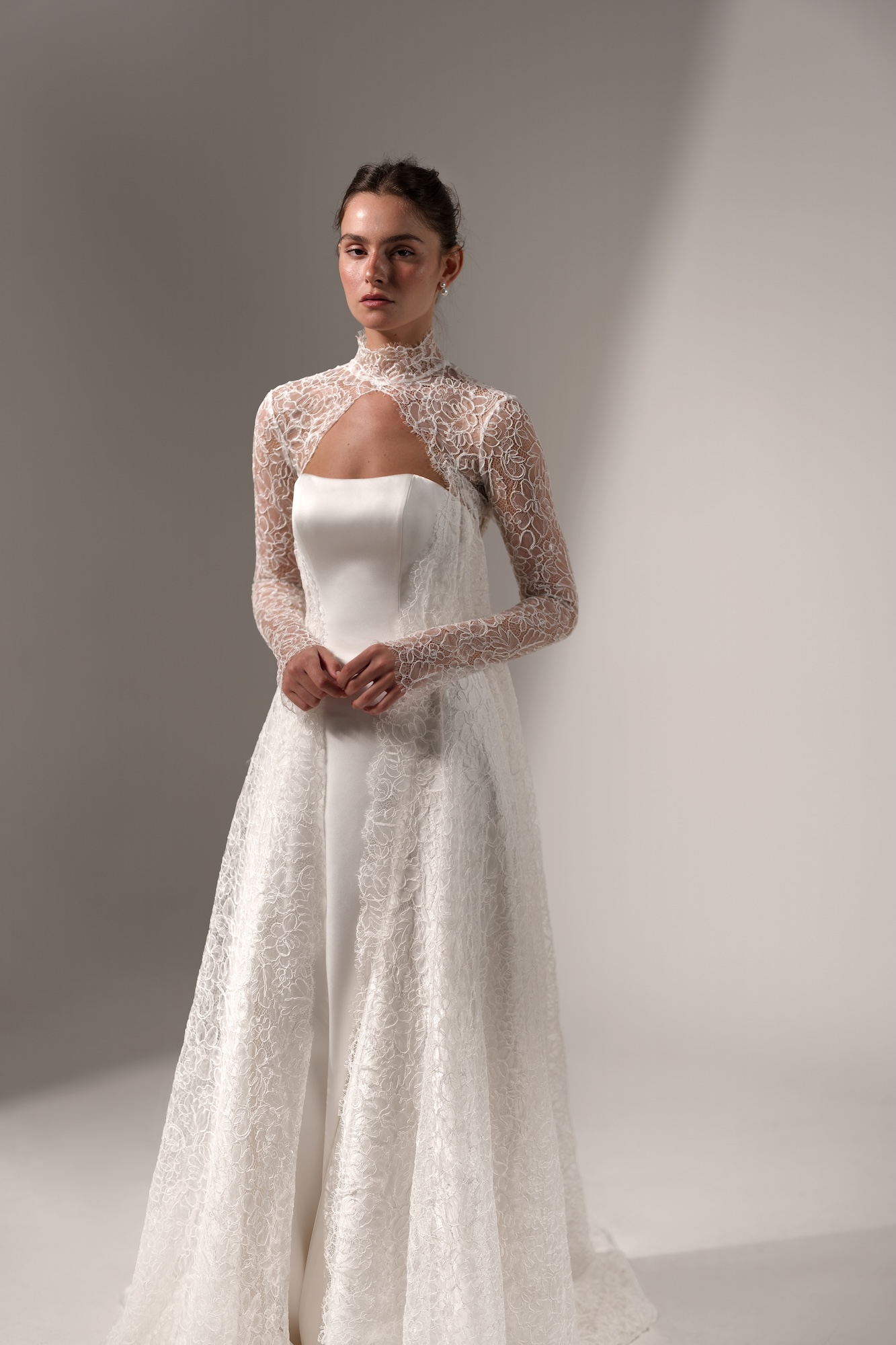 Muse by Lihi Hod, minimalist silk satin A-line wedding dress with a strapless neckline topped with delicate lace long sleeve and cape