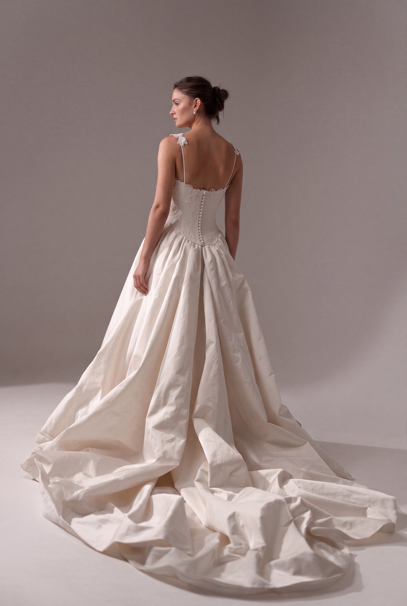 Back of the Odyssee by Lihi Hod dreamy wedding dress with silk duchess satin voluminous ballgown with a dramatic cathedral-length train and structured corseted bodice with full length buttons and a curved basque waist