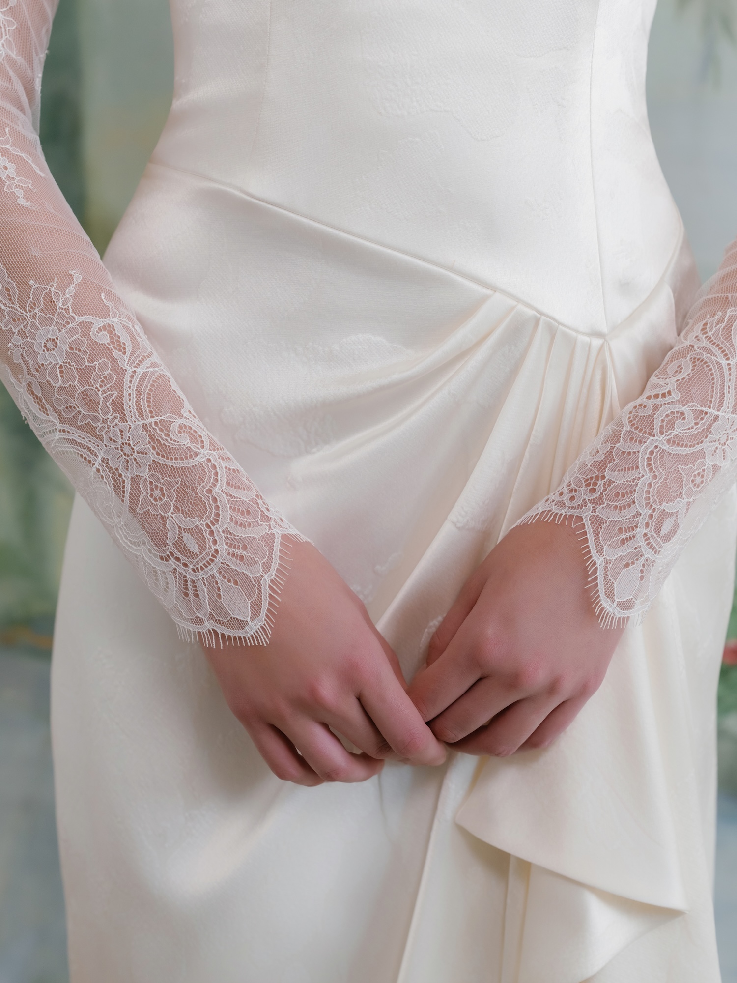 Close-up of Chantilly lace long sleeves with scallop trim at wrists and Embossed charmeuse fabric.