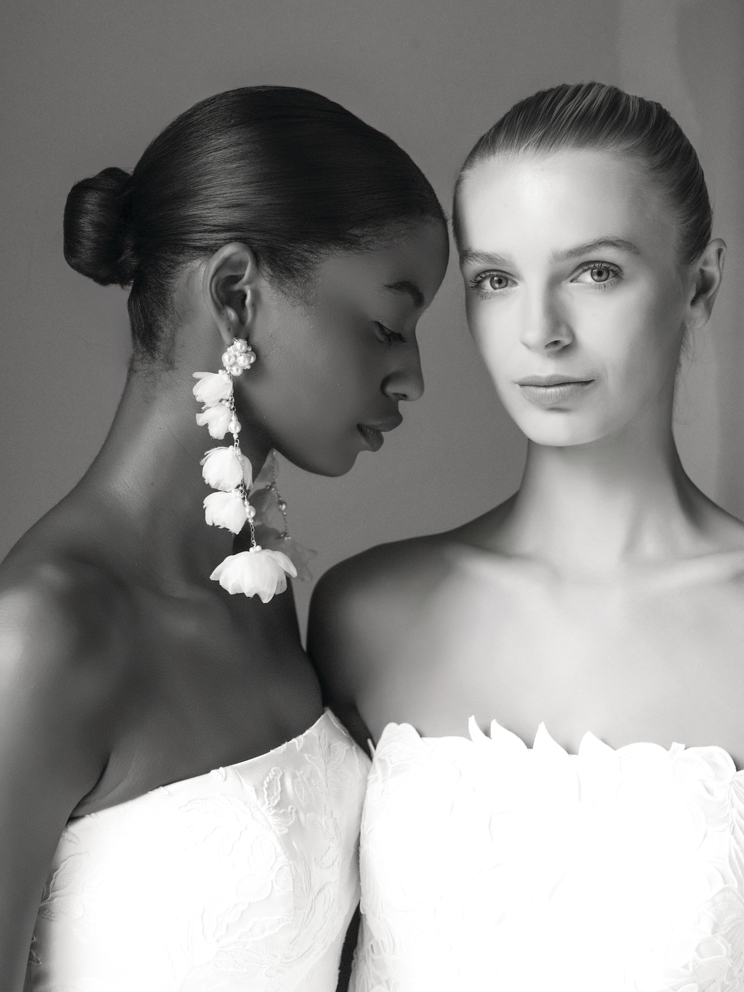 Black and white portraits fine art photography with black and white models in wedding dresses and long white earrings 