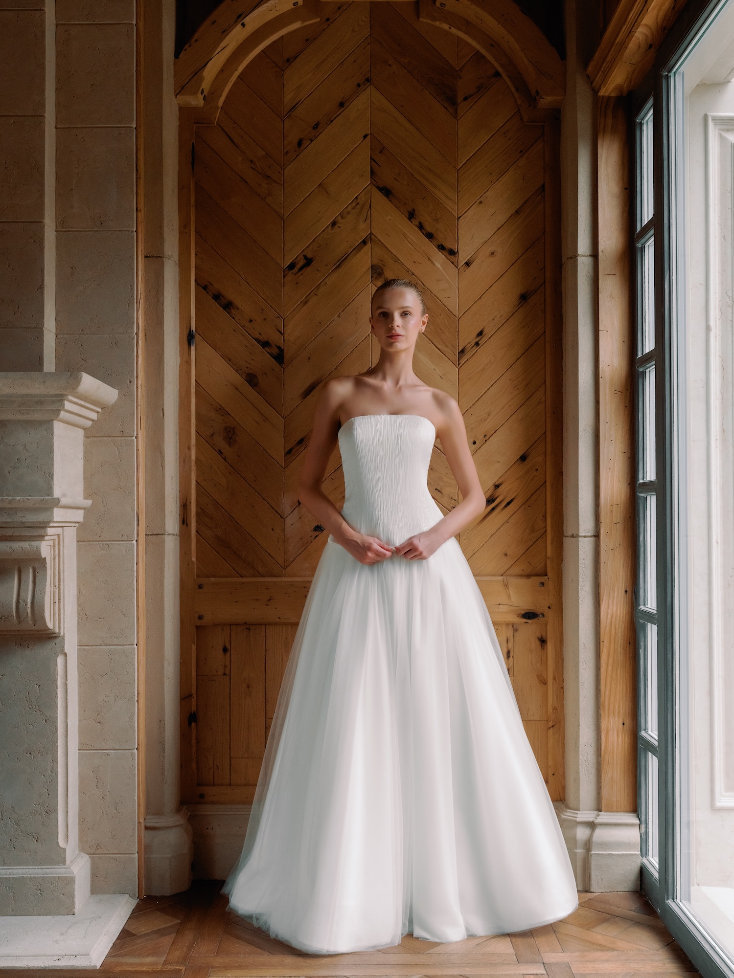 Bride in her satin back pleated crepe, straight across neckline with dropped waist, and English net tulle aline skirt.