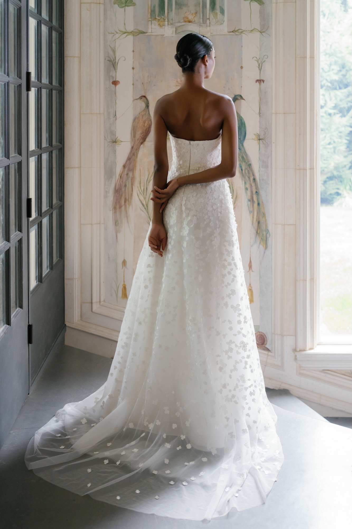Backside of a wedding dress with three dimensional floral lace soft, sweetheart neckline, natural waist with soft and sheer aline skirt.